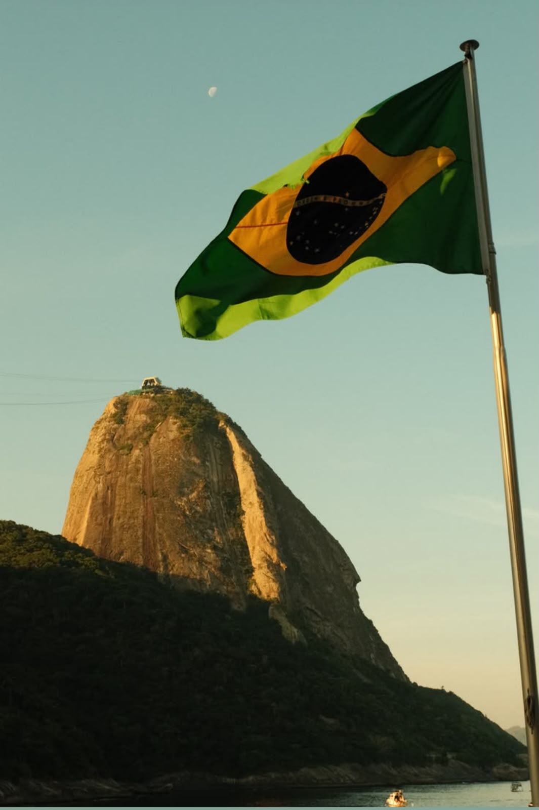 Bandiera brasiliana davanti al Pão de Açúcar al tramonto